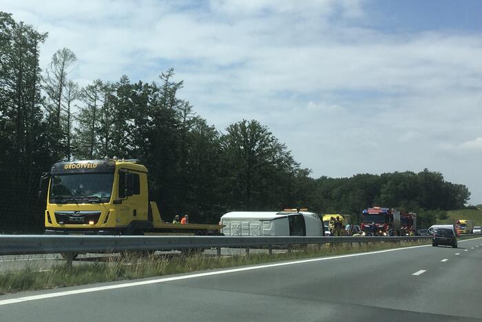 Bestelbus met aanhanger belandt op zijn kant