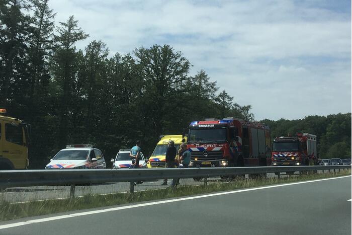 Bestelbus met aanhanger belandt op zijn kant