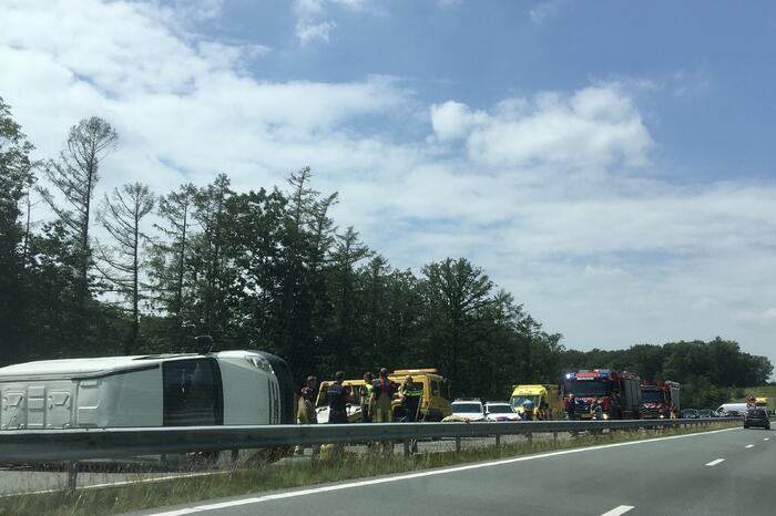 Bestelbus met aanhanger belandt op zijn kant