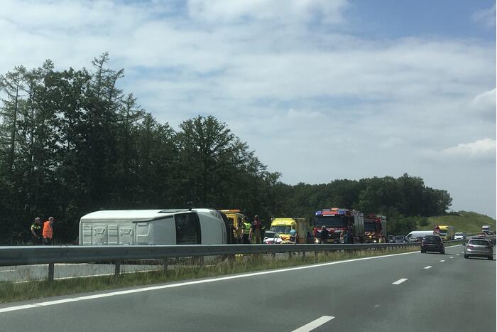 Bestelbus met aanhanger belandt op zijn kant
