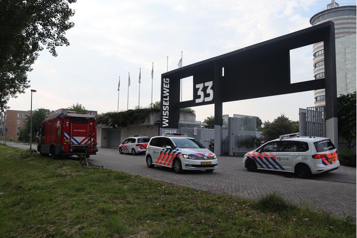 Man vast in hekwerk terrein kantoorgebouw