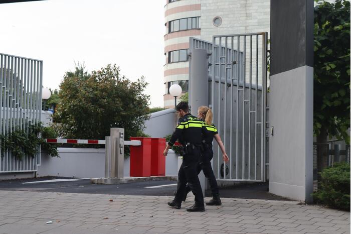Man vast in hekwerk terrein kantoorgebouw