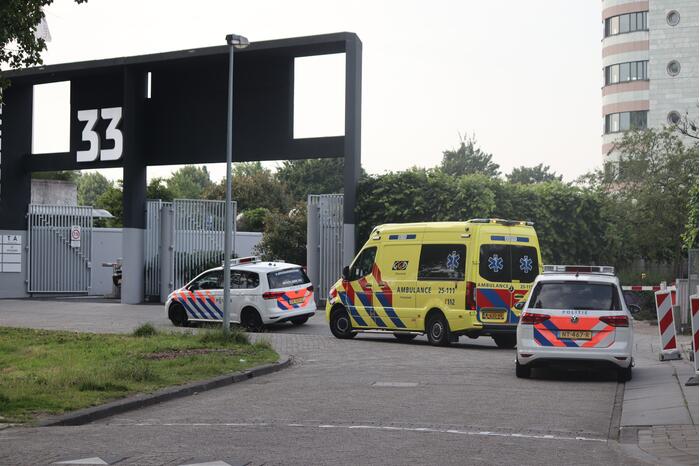 Man vast in hekwerk terrein kantoorgebouw