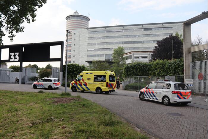 Man vast in hekwerk terrein kantoorgebouw