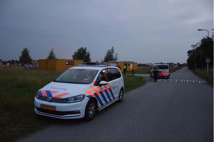 Brandstichting in stapel pallets op bouwterrein