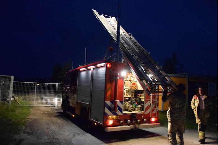 Brandstichting in stapel pallets op bouwterrein