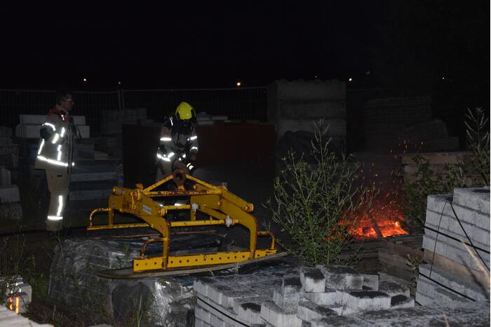 Brandstichting in stapel pallets op bouwterrein