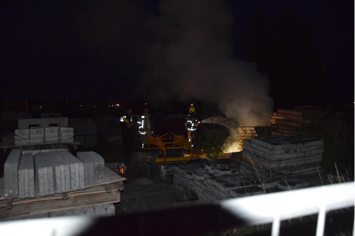 Brandstichting in stapel pallets op bouwterrein