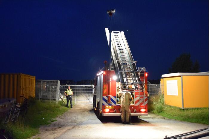 Brandstichting in stapel pallets op bouwterrein