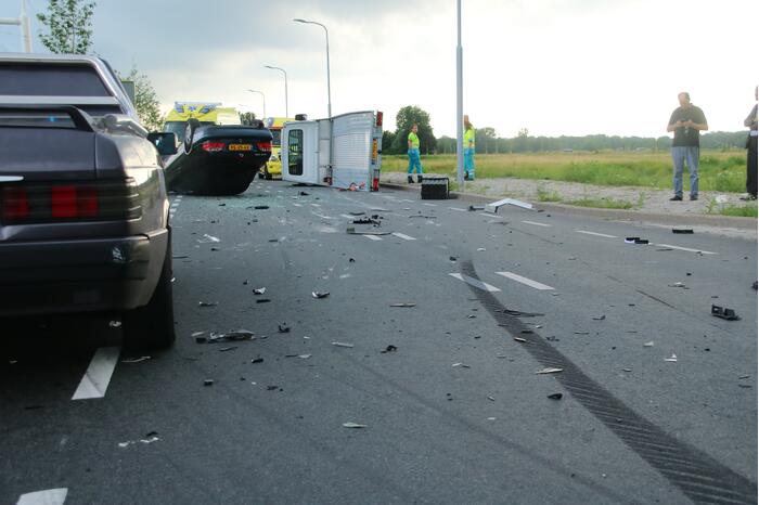 Autotransporter verliest auto en belandt op z'n kant na ongeval