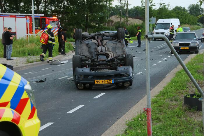 Autotransporter verliest auto en belandt op z'n kant na ongeval