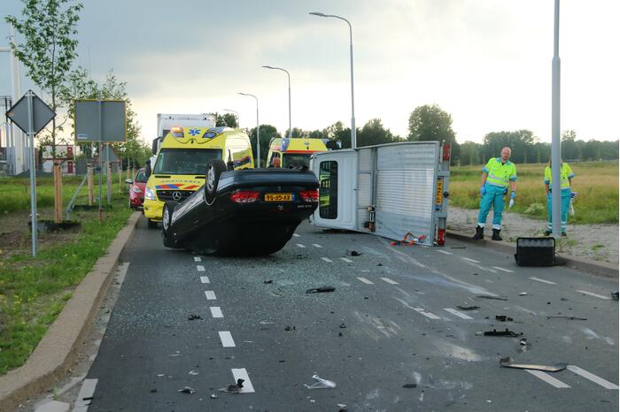 Autotransporter verliest auto en belandt op z'n kant na ongeval