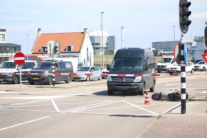 Auto botst op scooter voor ingang veerdienst
