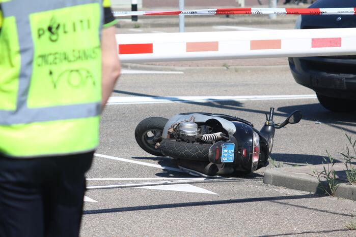 Auto botst op scooter voor ingang veerdienst
