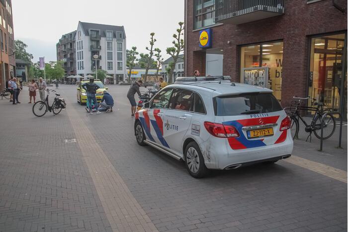 Fietsster gewond bij botsing met brommerrijder in winkelgebied