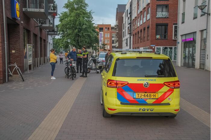Fietsster gewond bij botsing met brommerrijder in winkelgebied