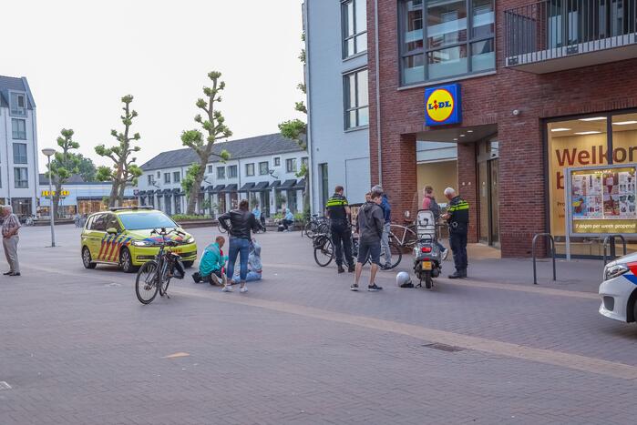 Fietsster gewond bij botsing met brommerrijder in winkelgebied