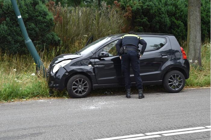 Automobilist parkeert auto tegen lantaarnpaal
