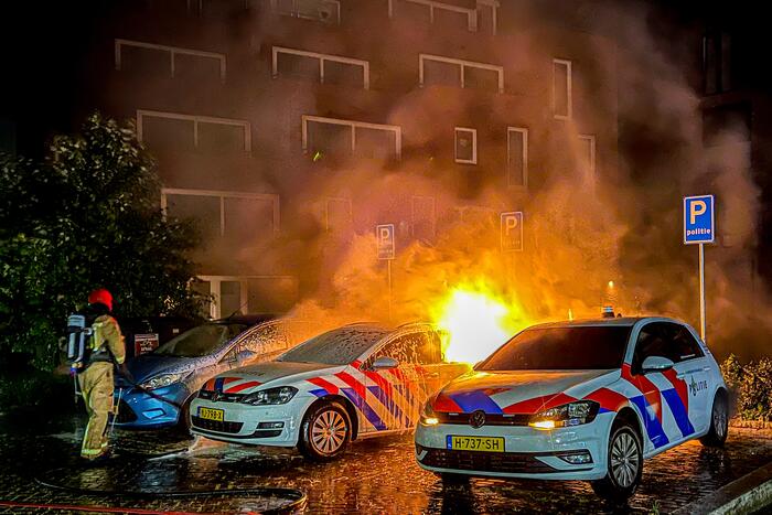 Twee politieauto's vliegen in brand