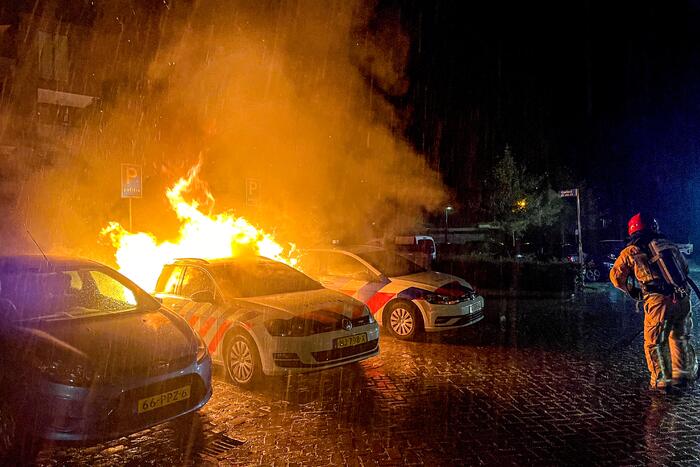 Twee politieauto's vliegen in brand
