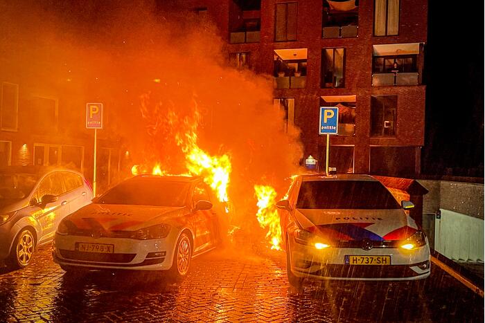 Twee politieauto's vliegen in brand