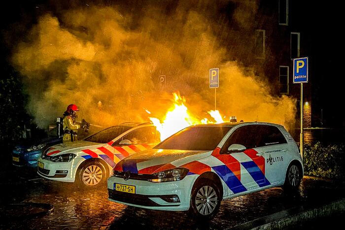 Twee politieauto's vliegen in brand