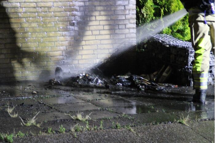 Schade aan muur door brandende papiercontainer