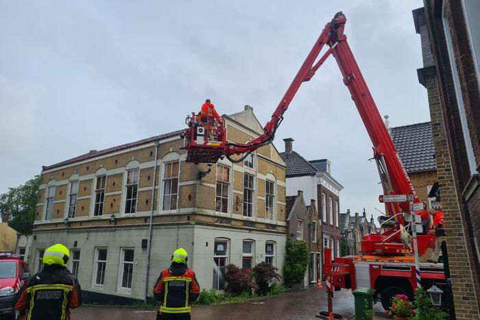 Stukken steen vallen van woning