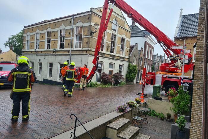 Stukken steen vallen van woning