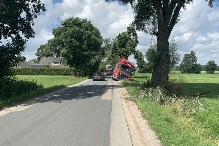 Vrachtwagen met oplegger komt vast te zitten in greppel