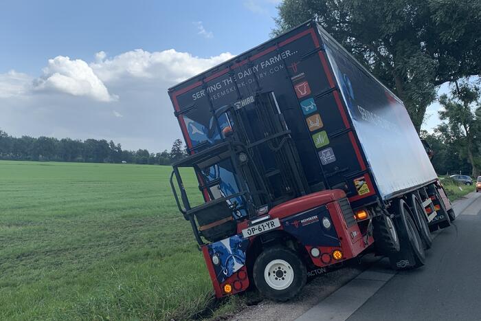 Vrachtwagen met oplegger komt vast te zitten in greppel