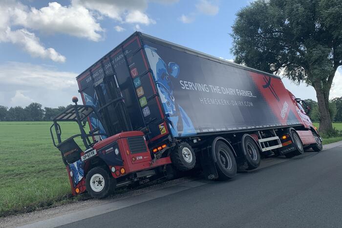 Vrachtwagen met oplegger komt vast te zitten in greppel