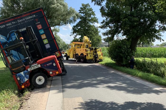 Vrachtwagen met oplegger komt vast te zitten in greppel