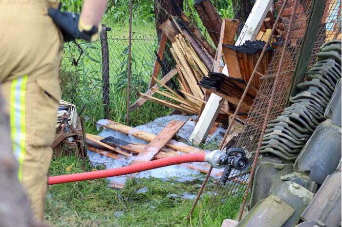 Brand in houtopslag slaat over naar schuur
