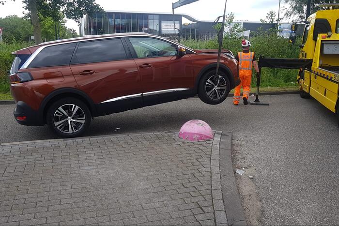 Auto belandt op betonnen sierbol