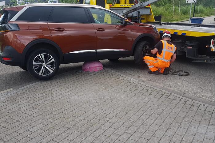 Auto belandt op betonnen sierbol