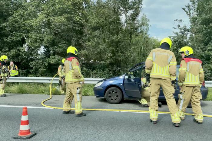 Brandweer blust brand in personenauto