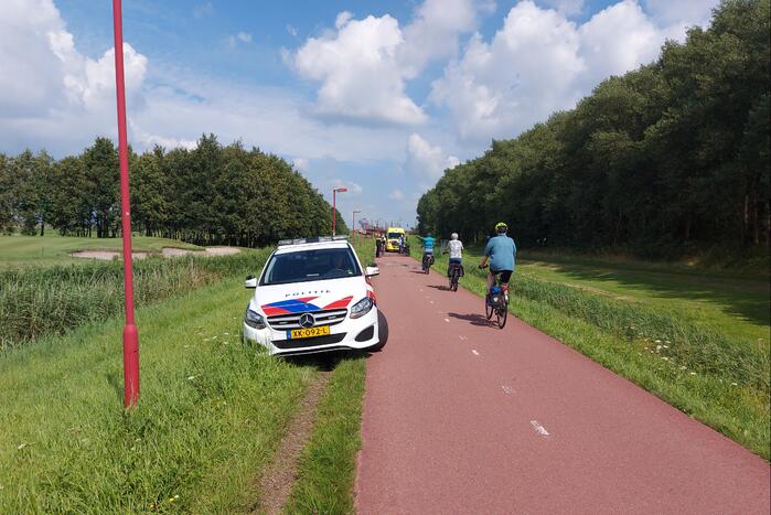 Vrouw rijdt met fiets sloot in
