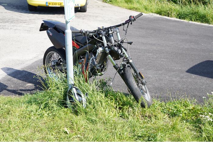 Bestuurder crossbrommer botst op geparkeerde auto