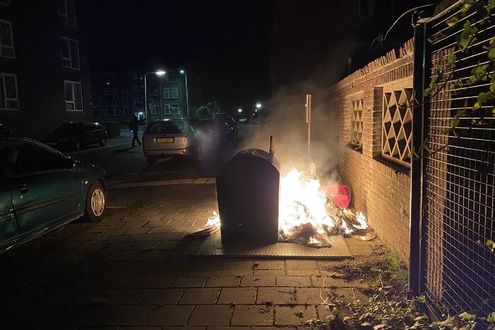 Brandweer blust brand bij container