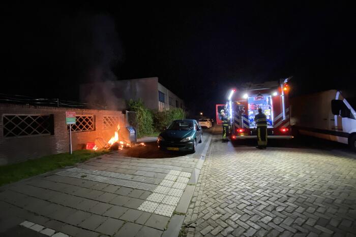 Brandweer blust brand bij container