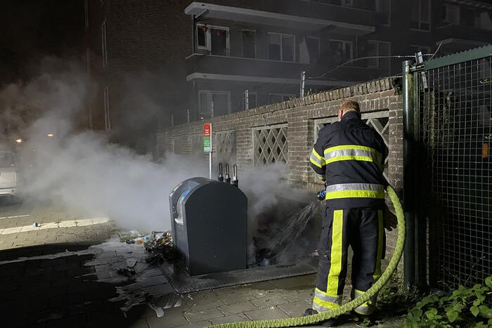 Brandweer blust brand bij container