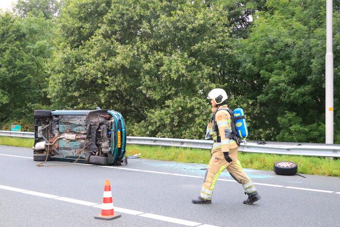 Auto glijdt over vangrail heen en belandt op zijn kop