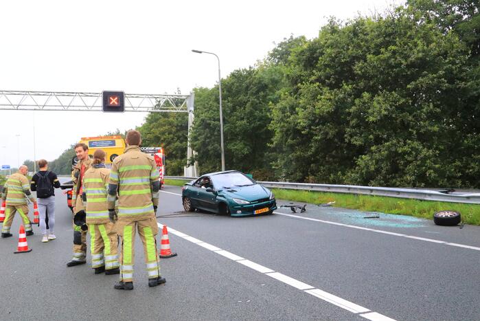 Auto glijdt over vangrail heen en belandt op zijn kop