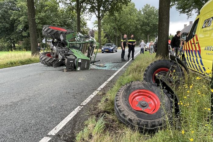 Tractor over de kop na botsing met boom