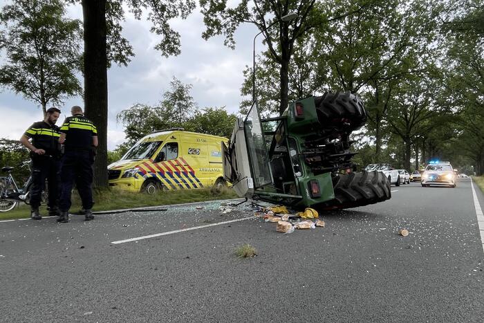 Tractor over de kop na botsing met boom