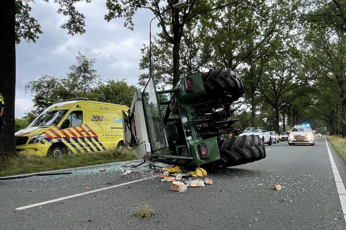Tractor over de kop na botsing met boom
