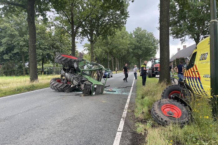 Tractor over de kop na botsing met boom