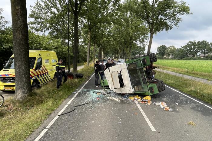 Tractor over de kop na botsing met boom