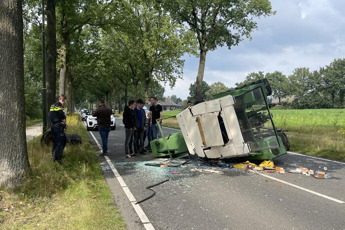 Tractor over de kop na botsing met boom